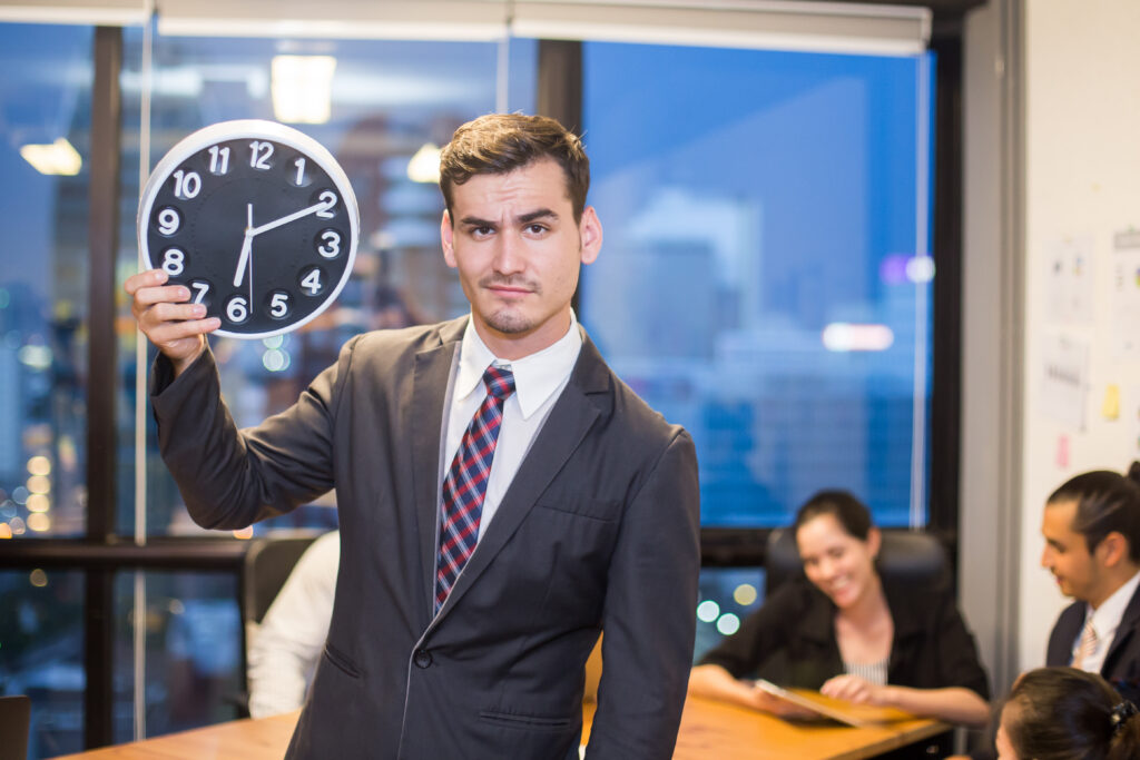 A business professional holding a clock.